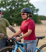 Woman on a gravel bike wearing maroon gravel jersey